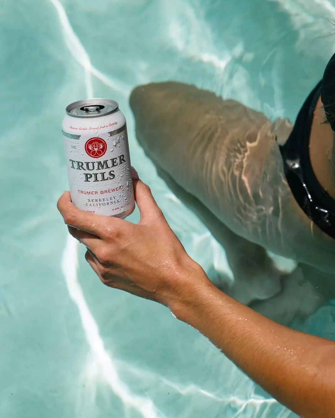 A toast of Trumer Pils beer classes with a sunset in the background