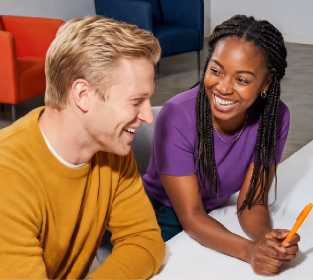 Two person sitting on a table and laughing