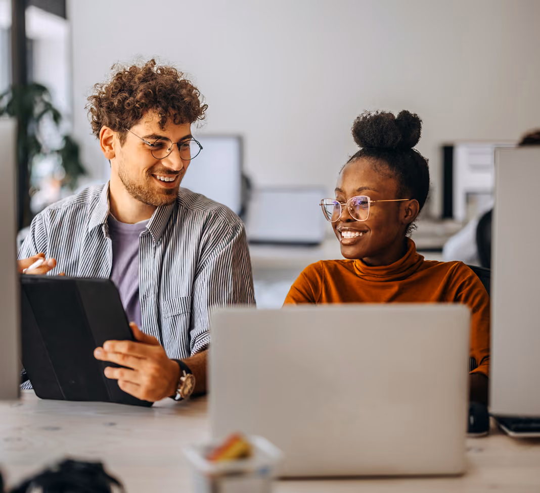Two person siting on a table with laptops