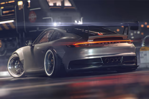 Silver Porsche sports car with a large rear spoiler parked on a wet street at night with a blurred vehicle in the background.