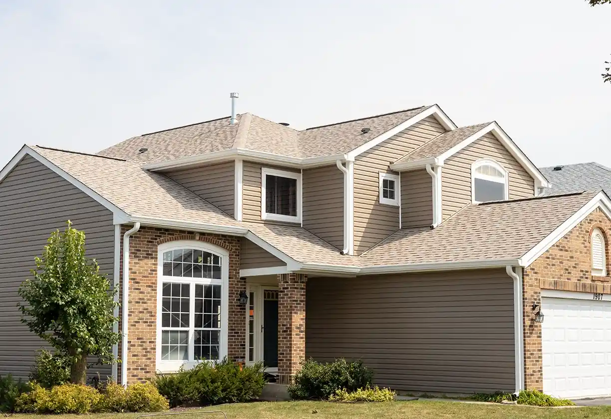 Home with a fully remodeled exterior in a tan color roof and siding.