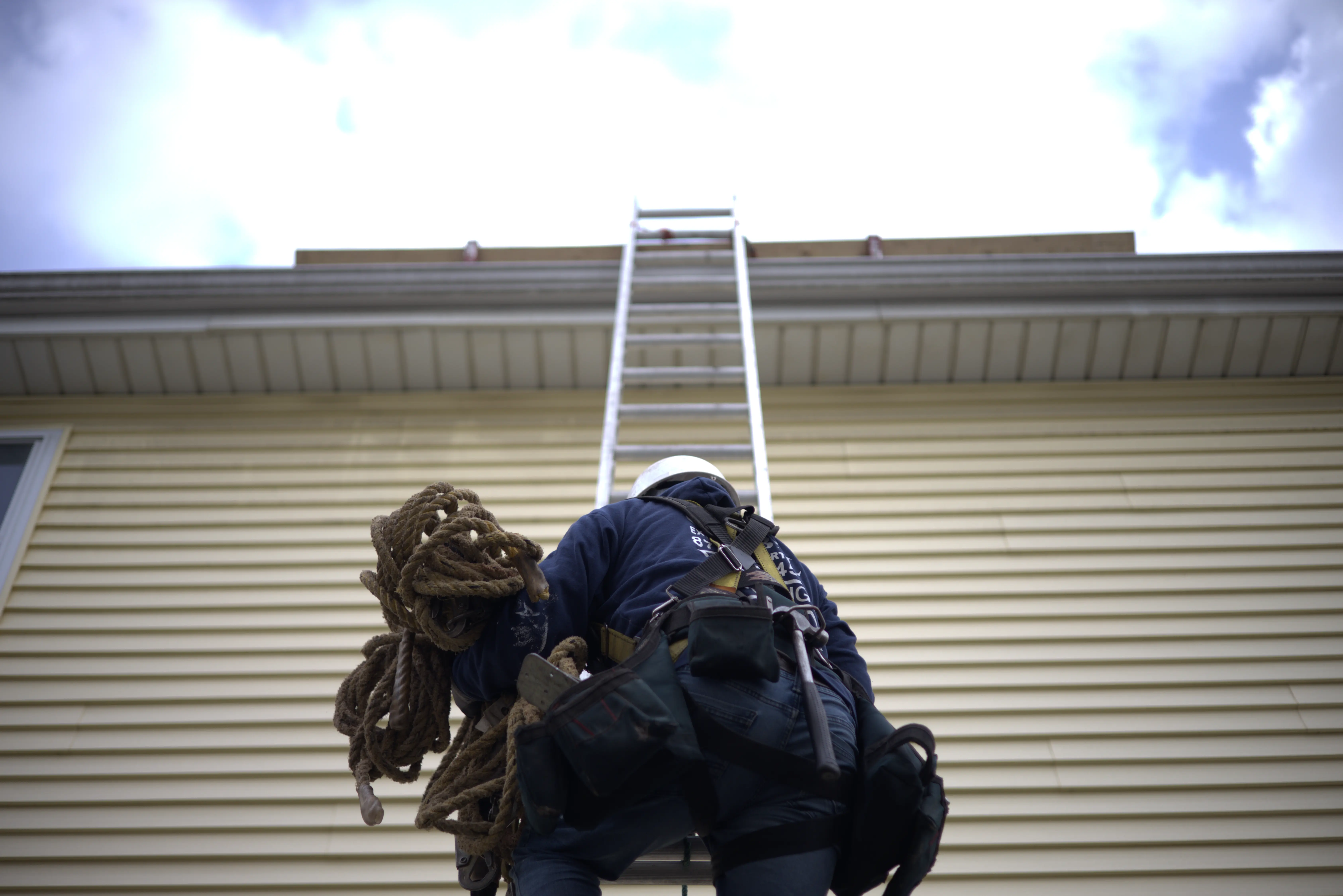 Global Exterior Experts Roofer Climbing Ladder To Roof