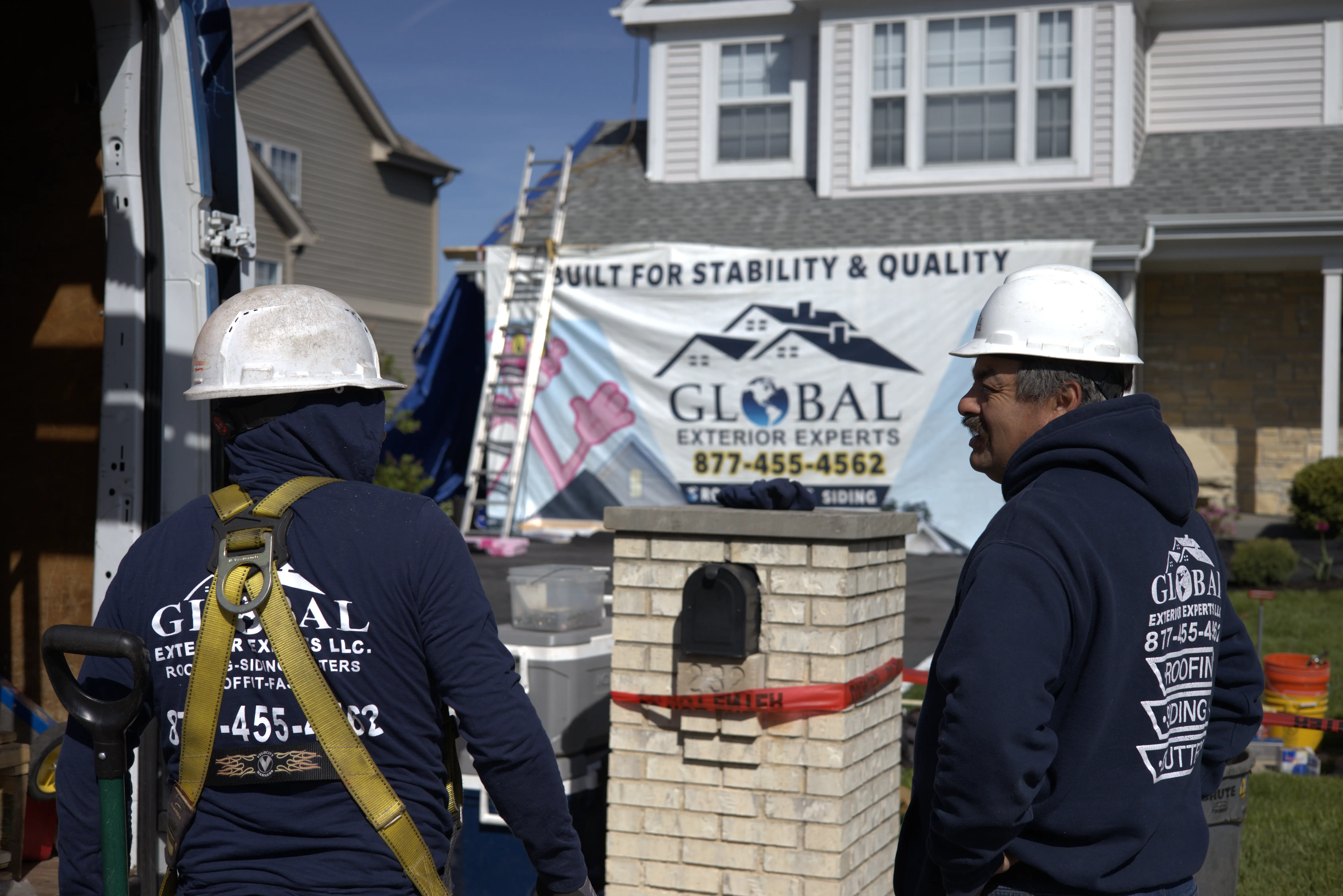 Global Exterior Experts Roofing Employees Standing Infront Of In-Progress Roof Replacement