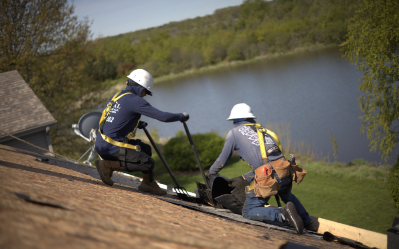 GEE Roofers Tearing Off Shingles On A Residential Roof