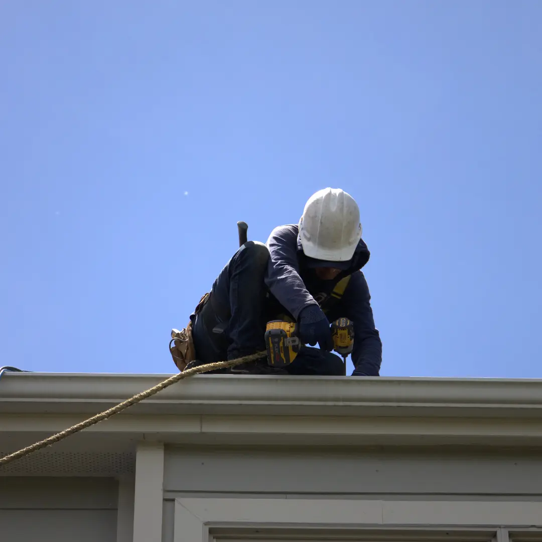 Global Exterior Experts Roofer Installing Residential roof With Screwdriver