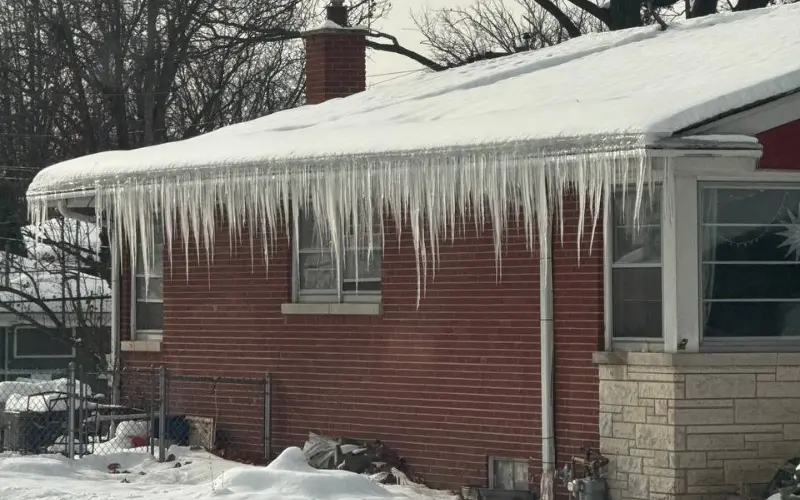 Icicles Forming In A Residential homes gutters called ice dams