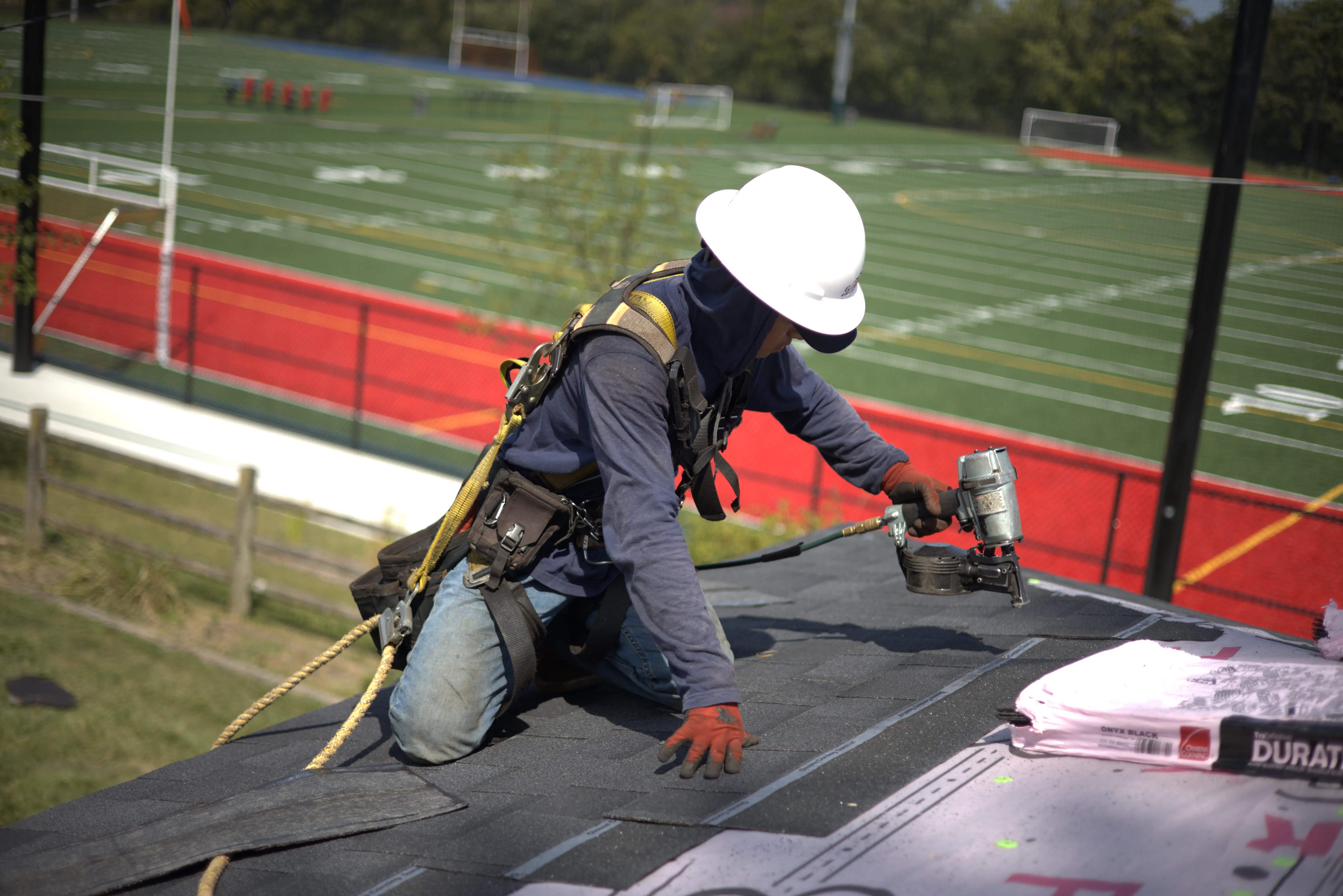 Residential Roofer Installing Shingles On Residential Roof