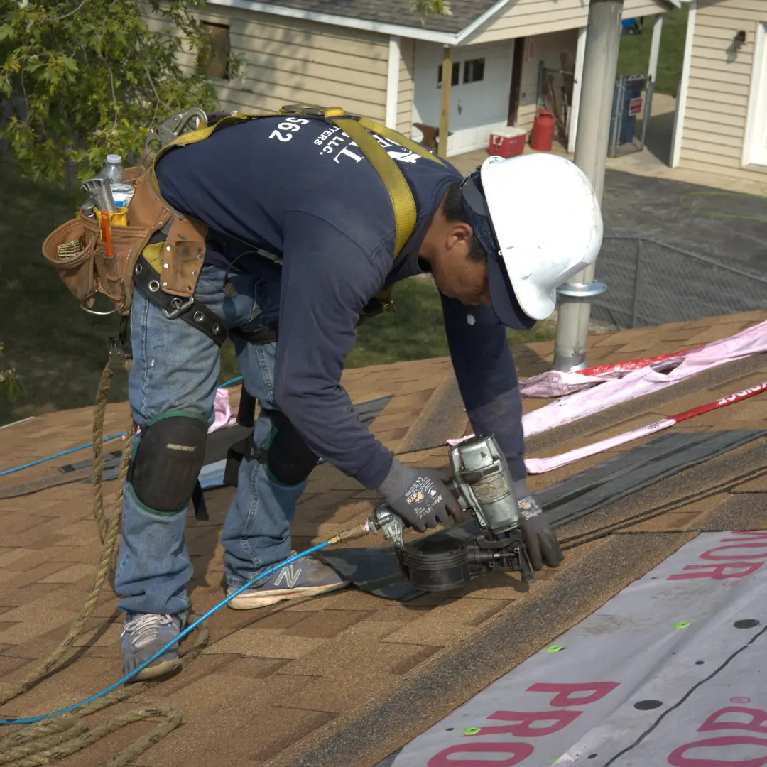 Roofer Installing Shingle Roof On Residential Home