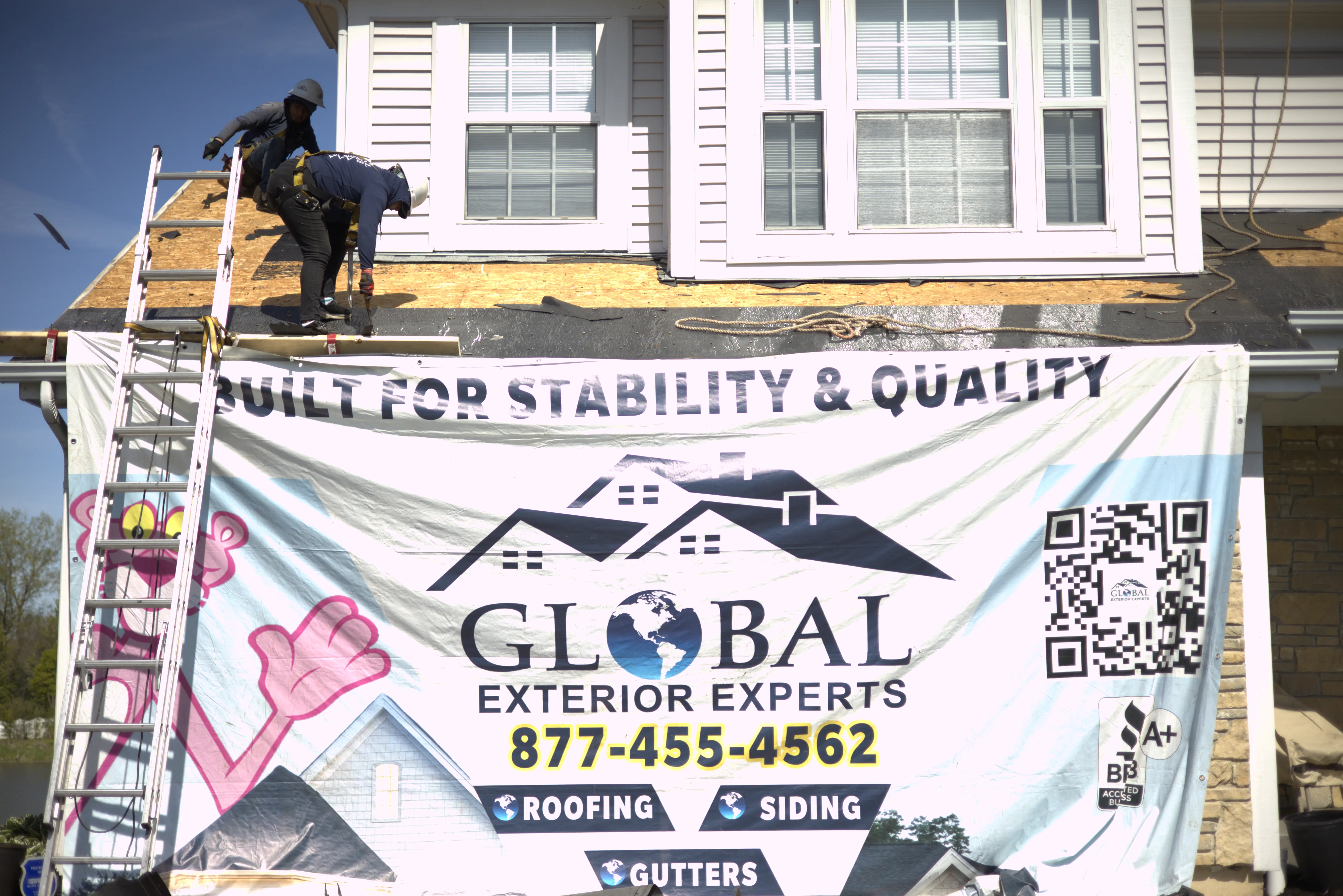 Roofers Ontop of Residential Home Removing Old Shingles