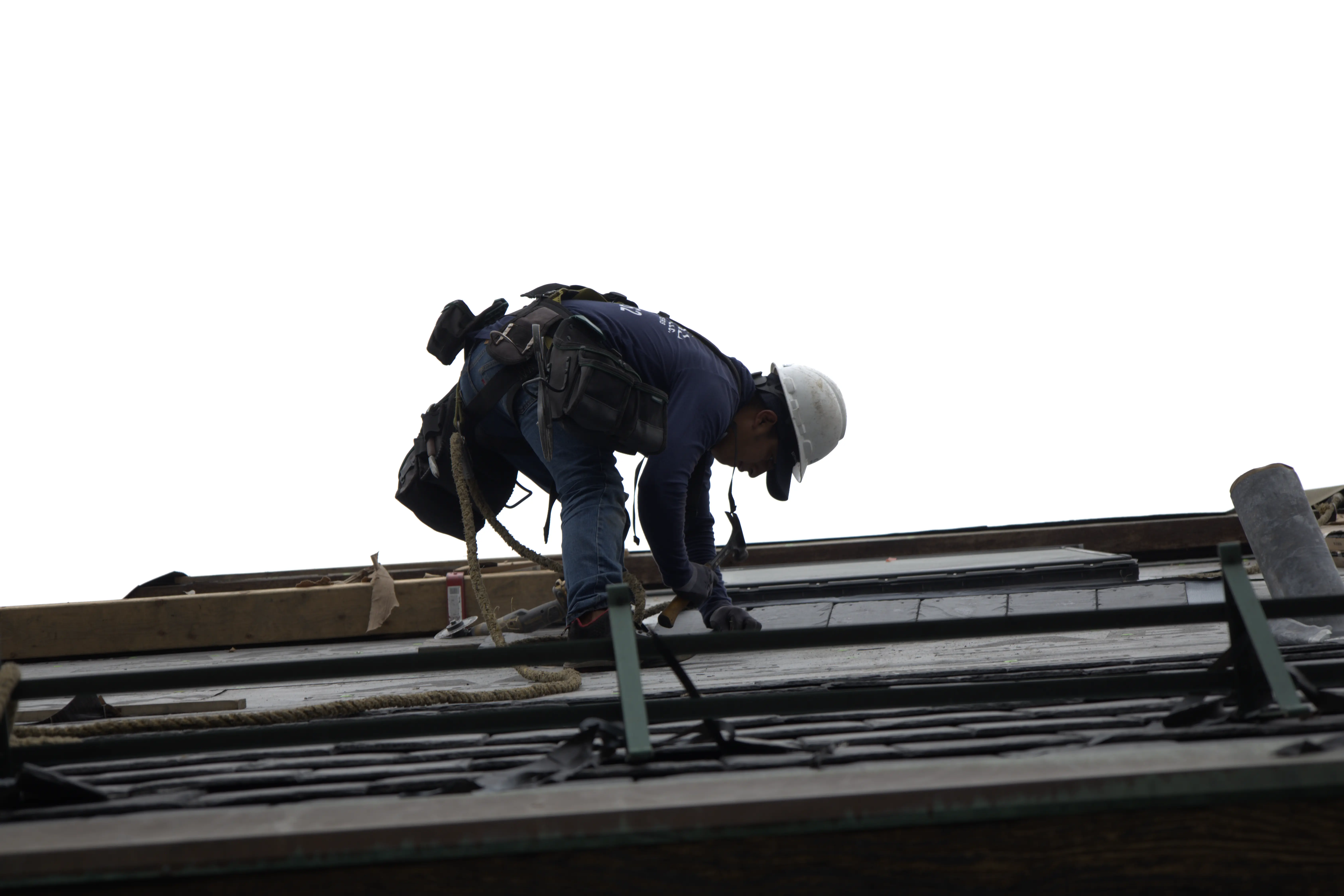Roofer Installing Natural Slate Roof On Residential Home