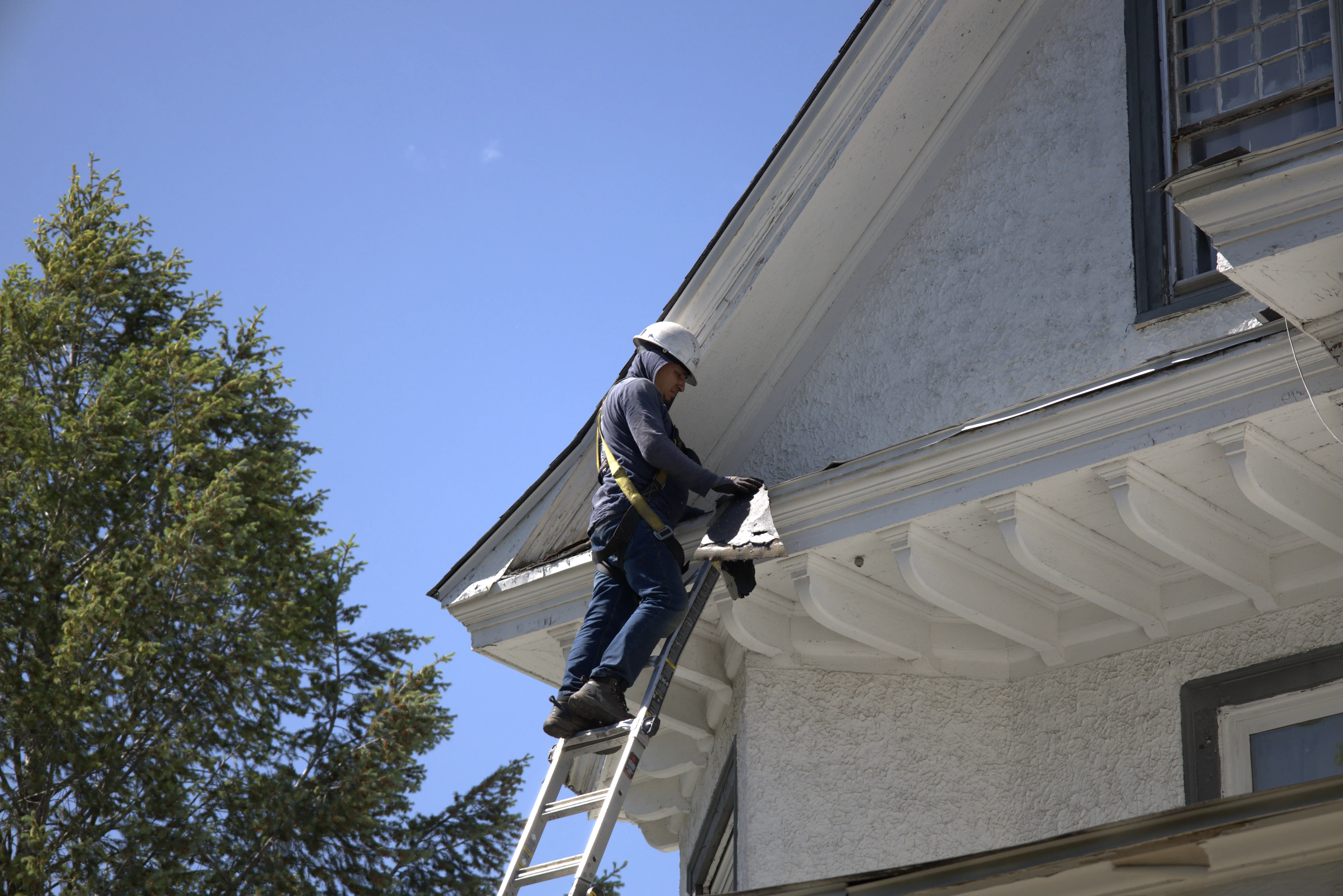 Roofer Tearing Off Shingle Roof From Residential Home