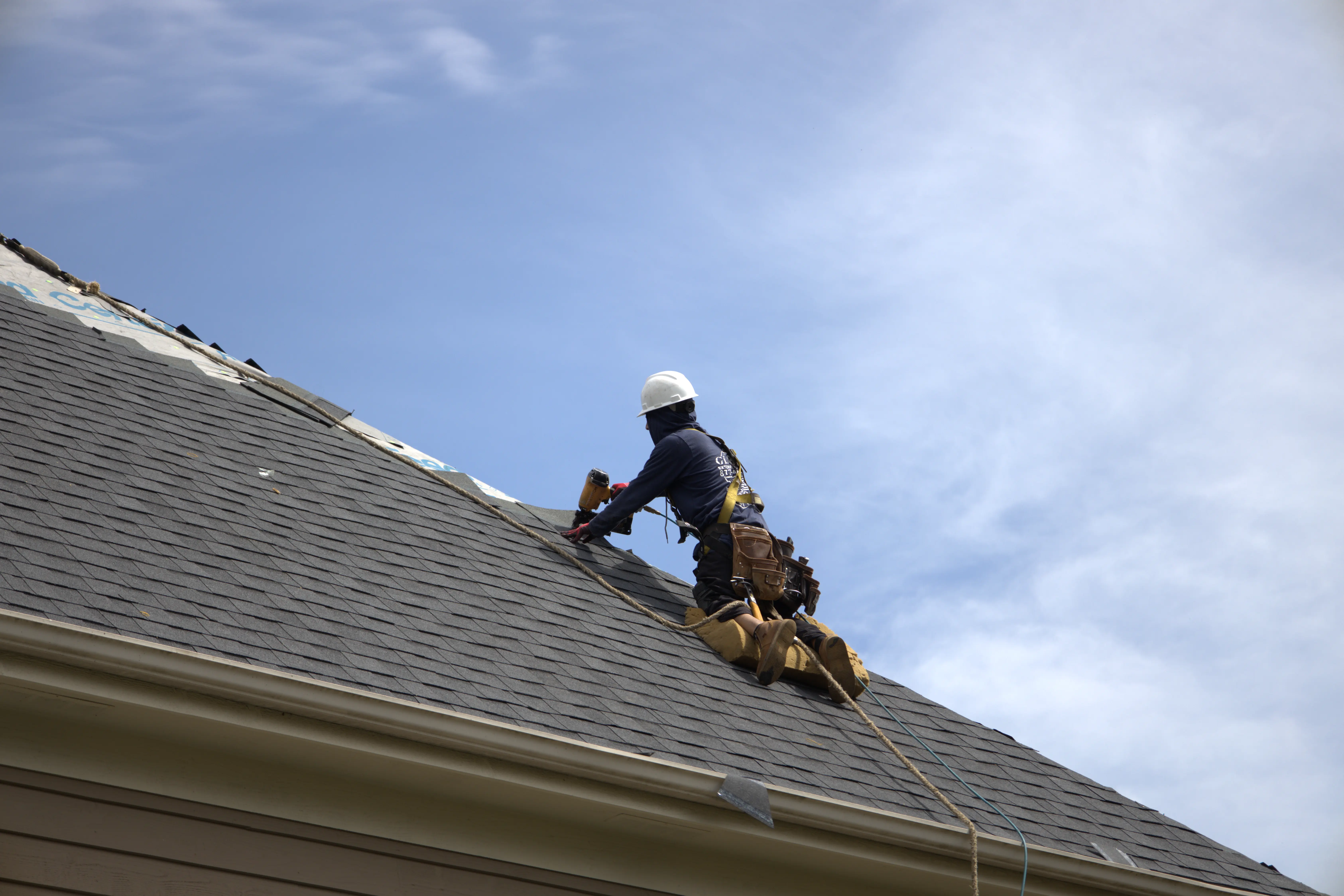 Residential Roofer Installing Shingles On Residential Roof