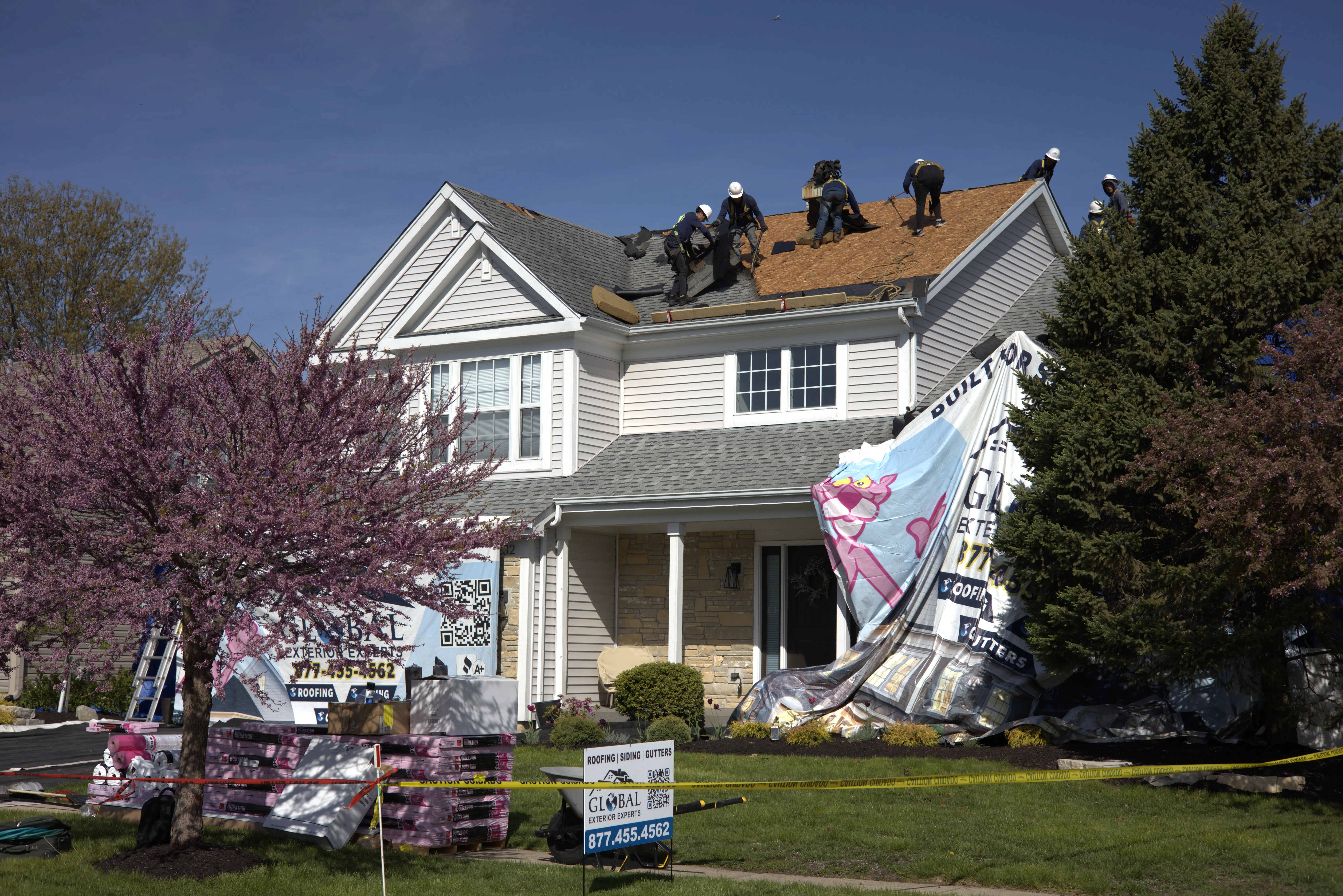 Roofers Tearing Off Old Roof On Residential Home