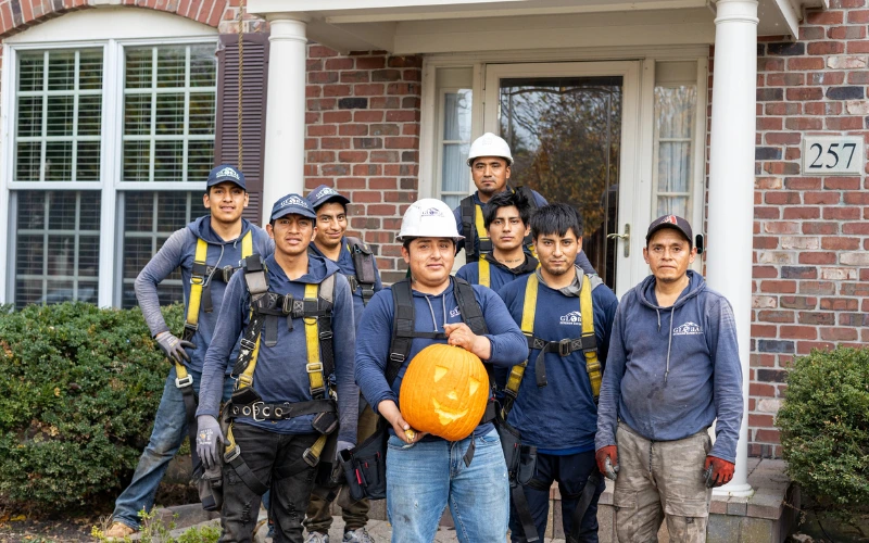 Global Exterior Experts Roofers Holding Pumpkin