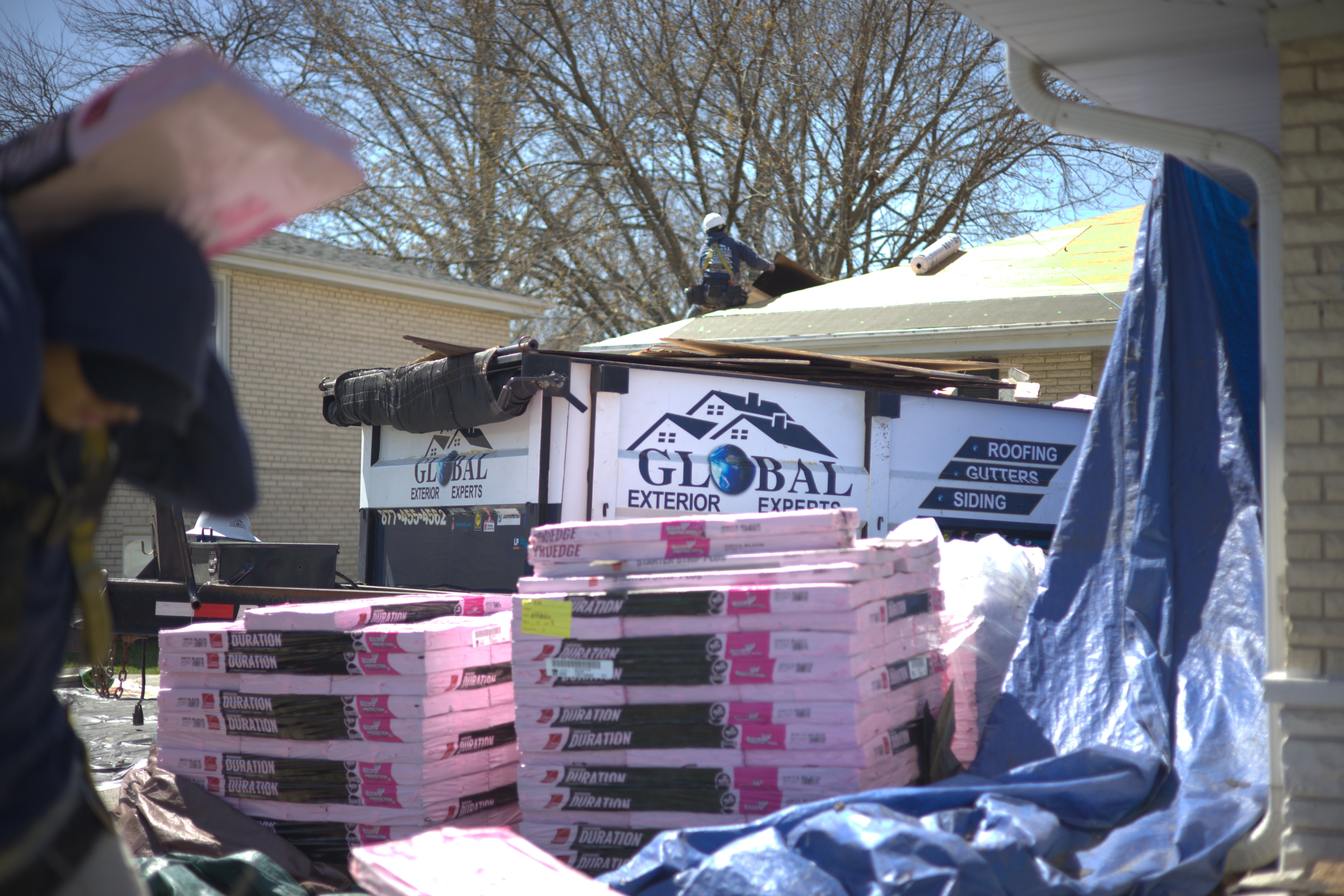 Dump Trailer Parked Infront of residential roof project for full roof replacement