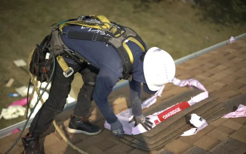 Roofer Taking apart and installing owen's corning shingle bundle