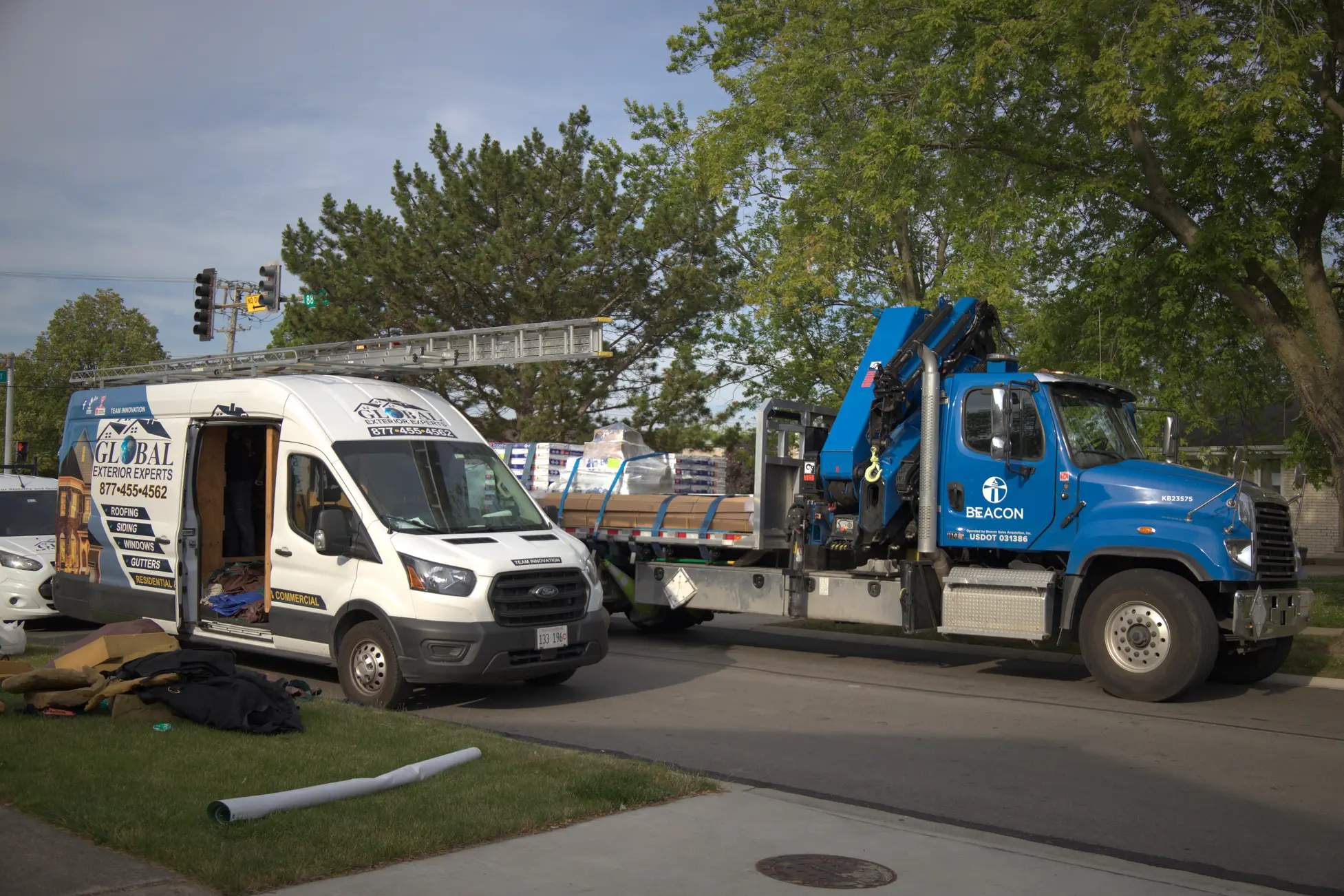 Beacon Material Delivery Truck parked Next To Global Exterior Experts Van For Residential Roof Replacement