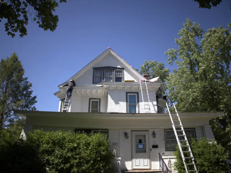 Roofers Replacing A Roof On Historic Residential Home