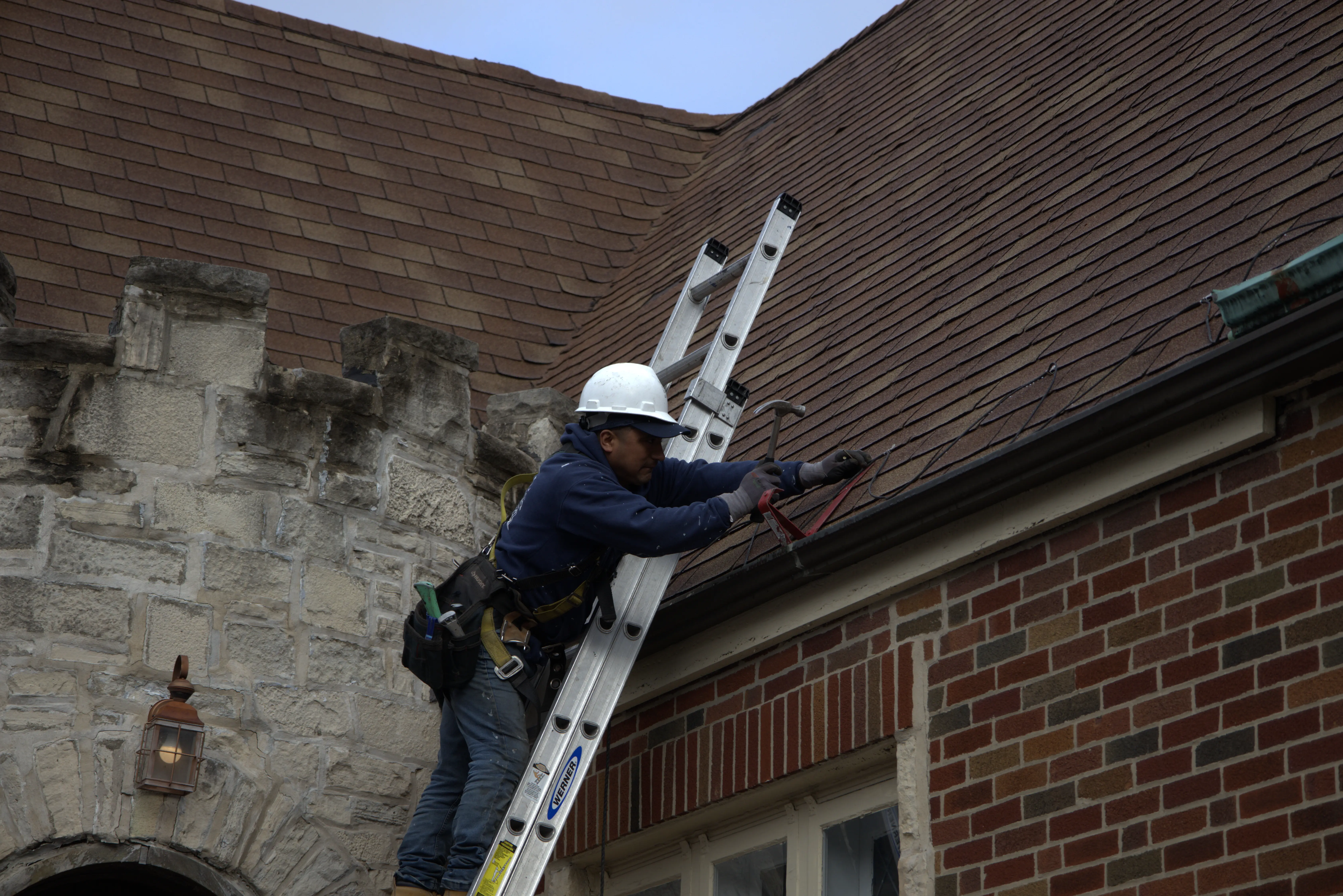 Roofer Inspecting Red Roof Before Installing New Shingles