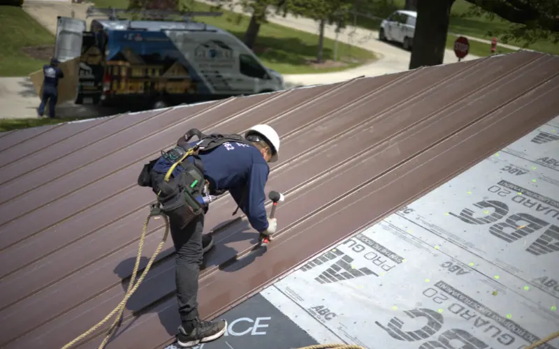 Metal Roofer Hammering Roof On Residential Roof
