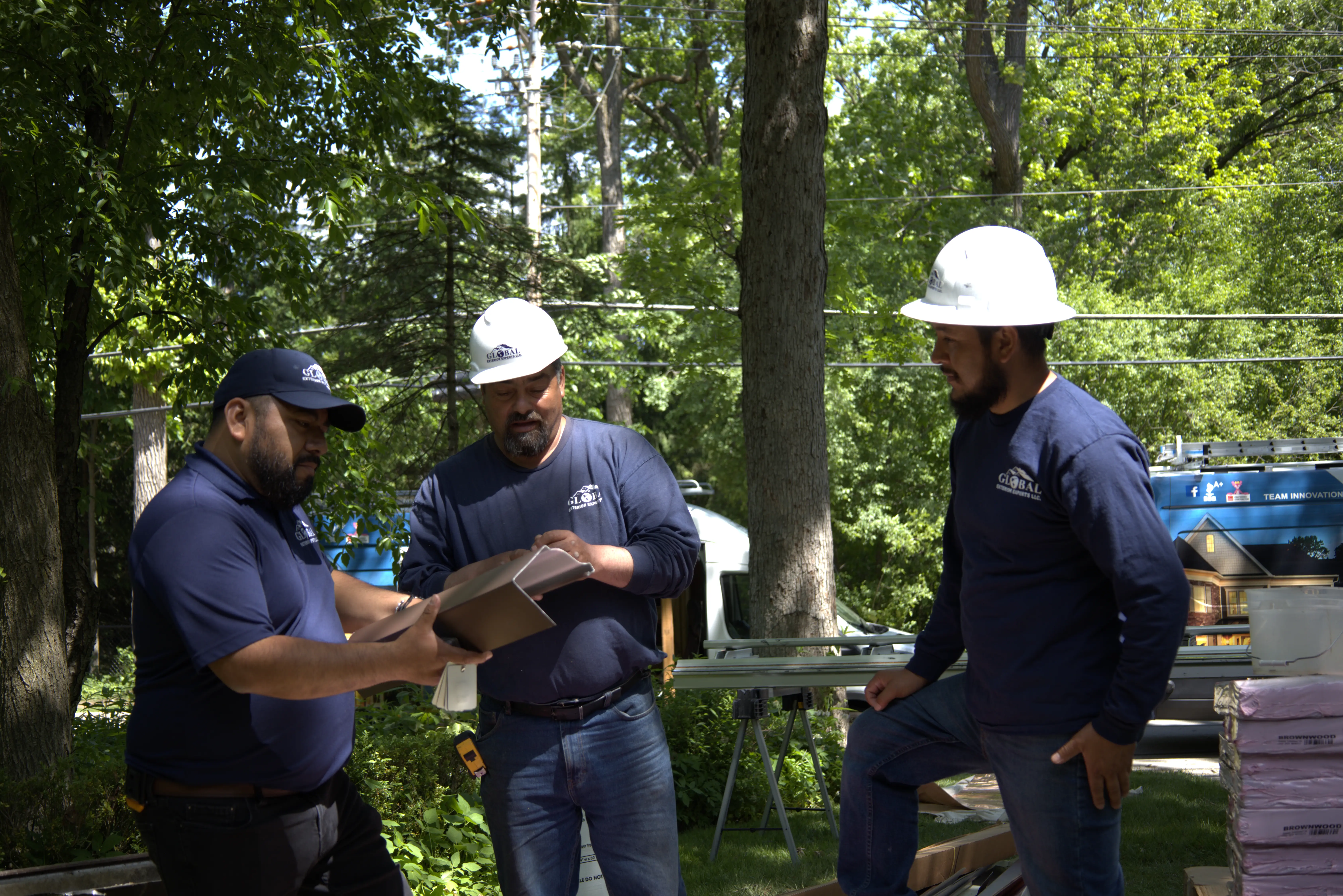 3 Roofers Inspecting A Gutter