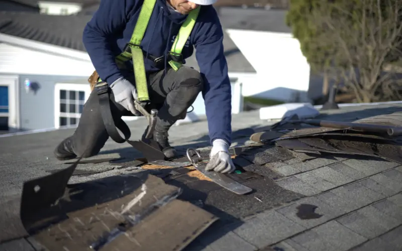 Roofer Setting Up Tie Down Point Before Roof Replacement