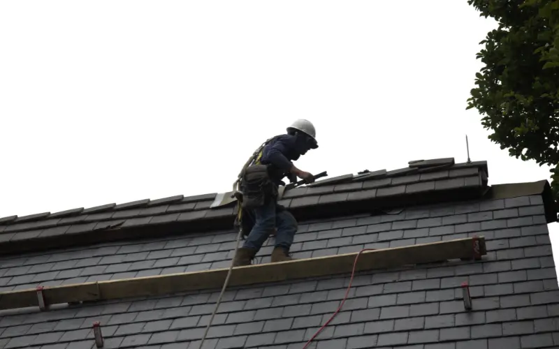Roofer On Roof During Roof Replacement