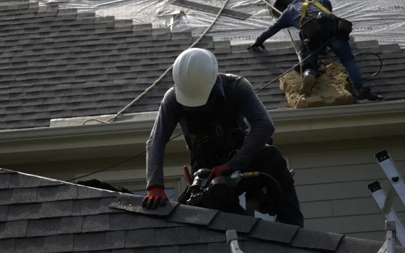 Roofer Installing Shingle Ridge On Residential Roof