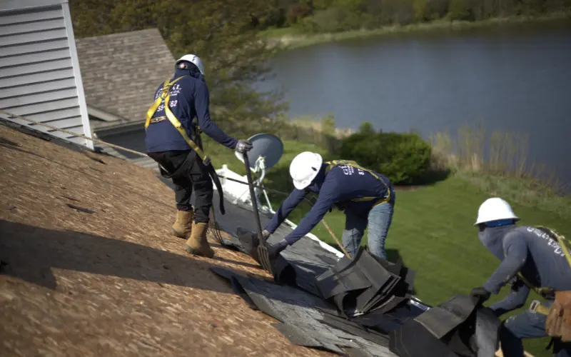 A Team Of Roofers In The Process Of Replacing A Shingle Roof