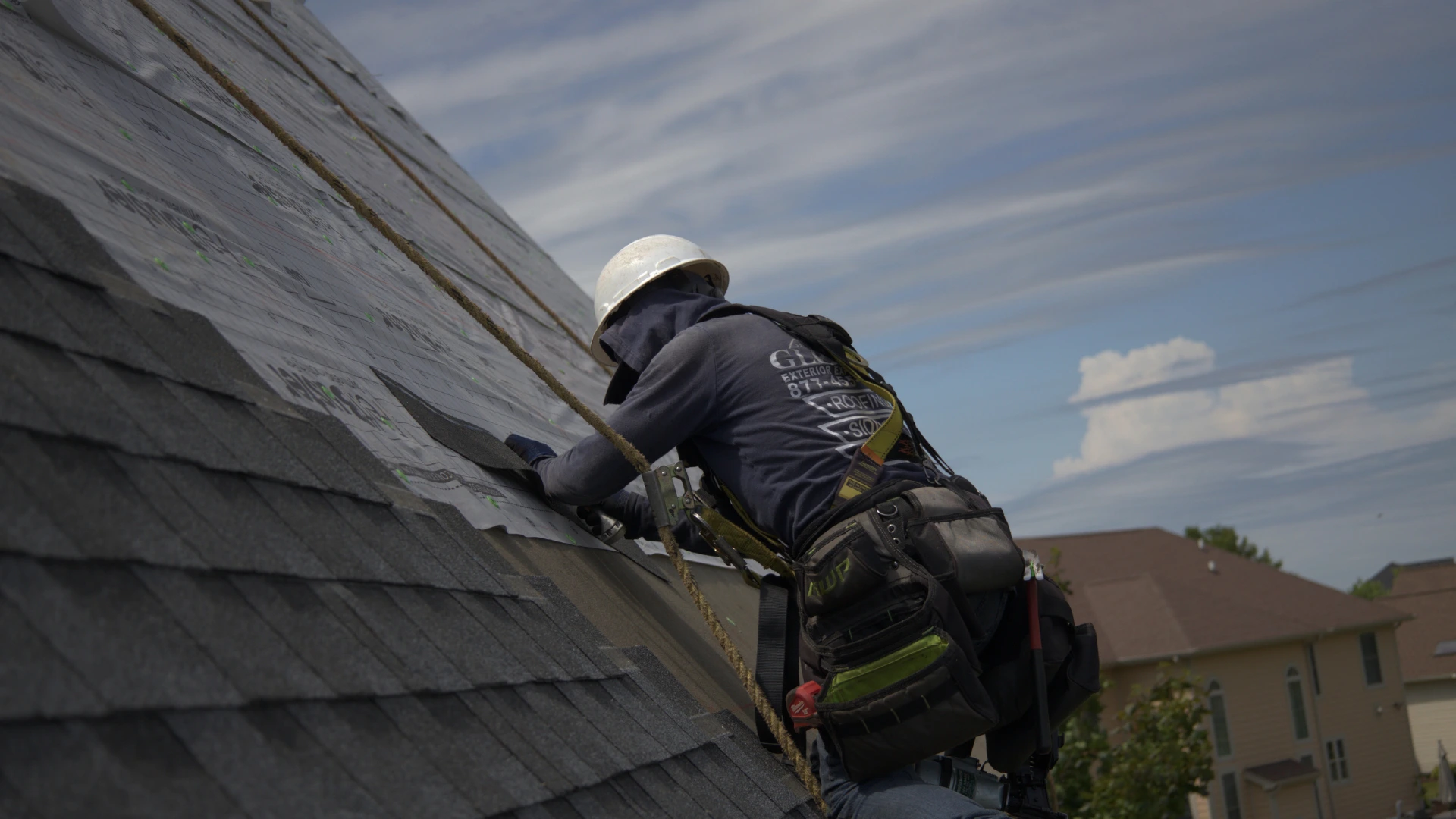 Roofer Installing Shingle Roof On Steep Residential Roof