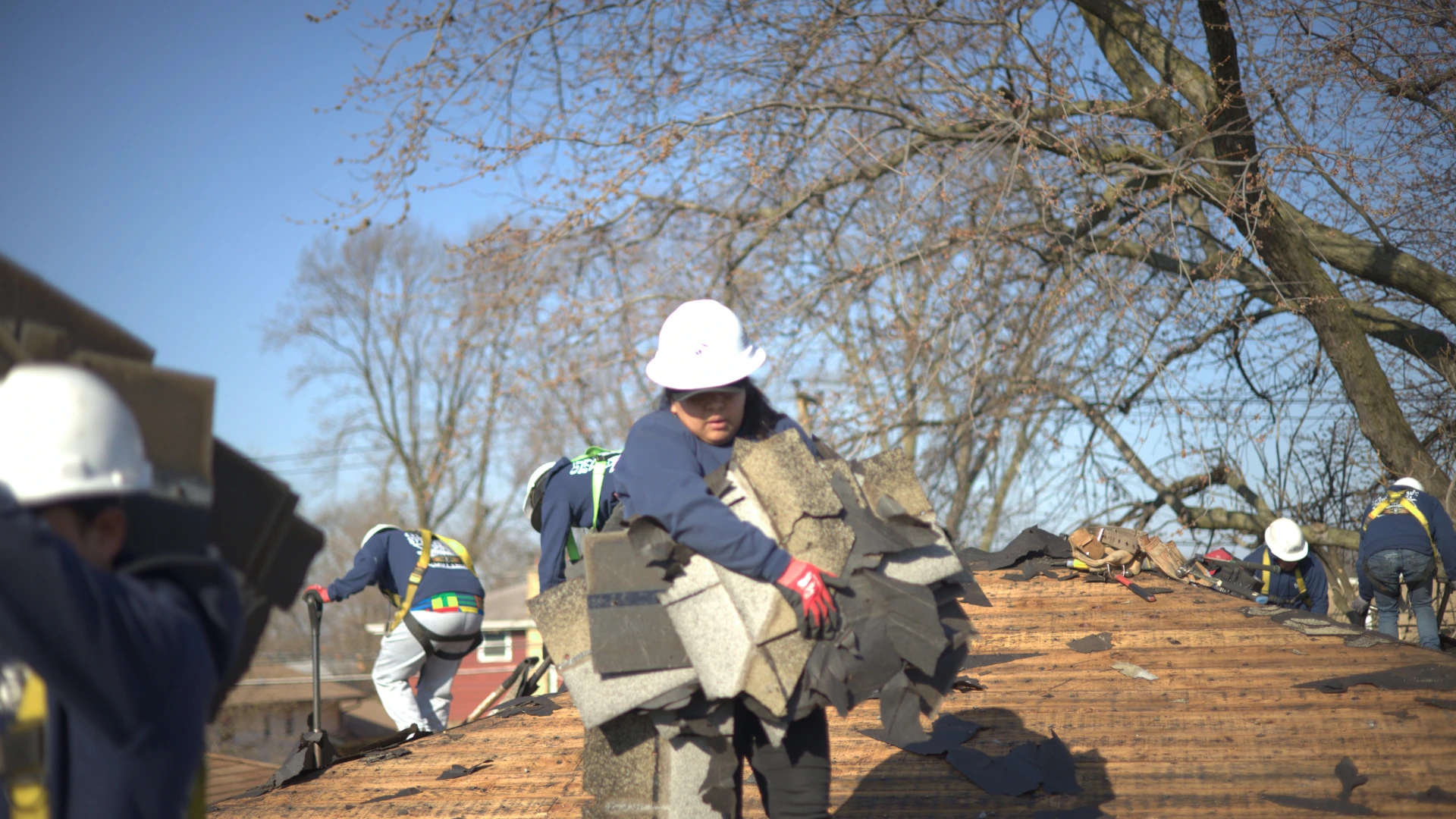 Roofer Picking Up Shingles During Cleanup