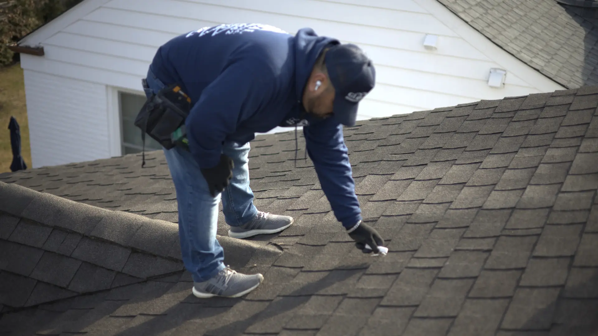 Trusted Roofer Inspecting Roof With Caulk Right Above Rige