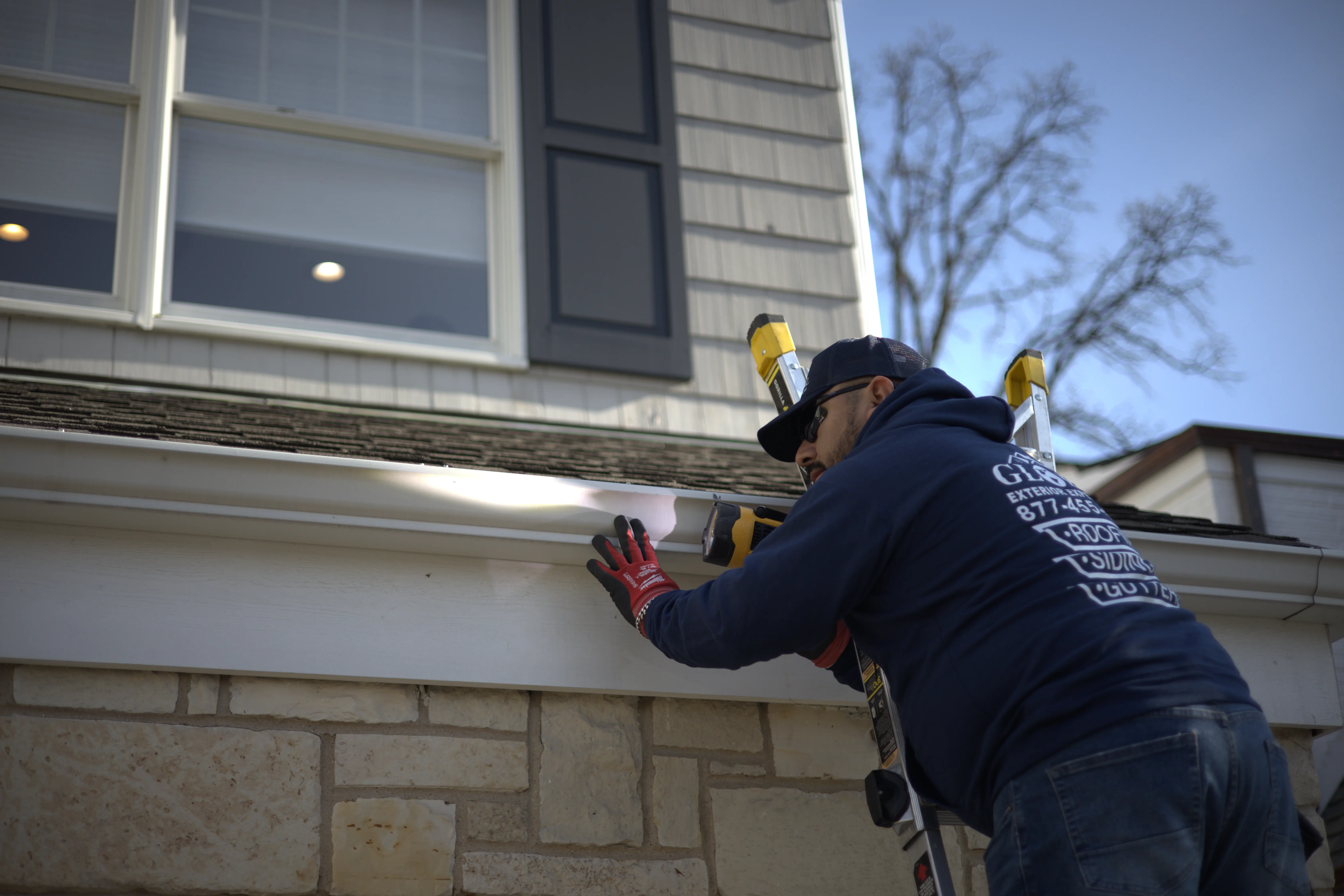 Gutter inspection for storm damage with flashlight