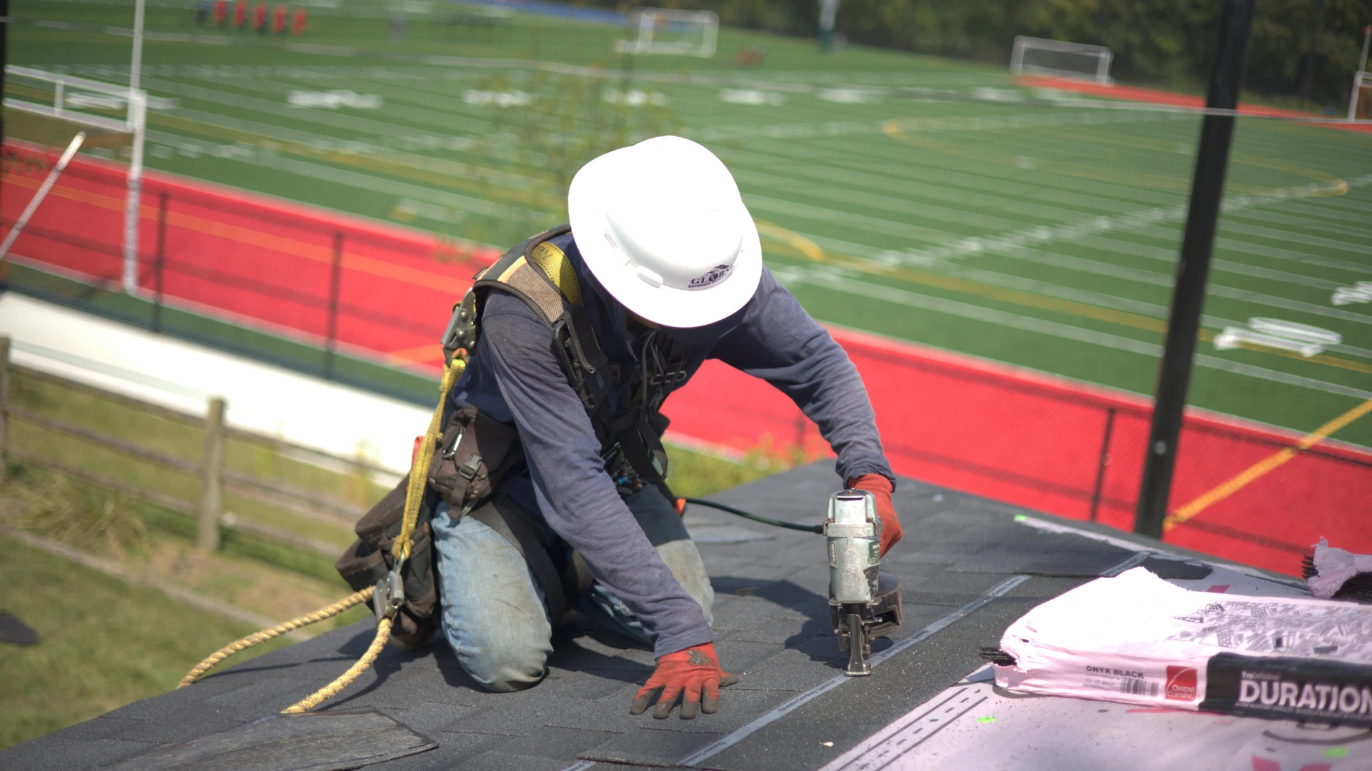 Installing Shingle Roof Infront Of Football Field