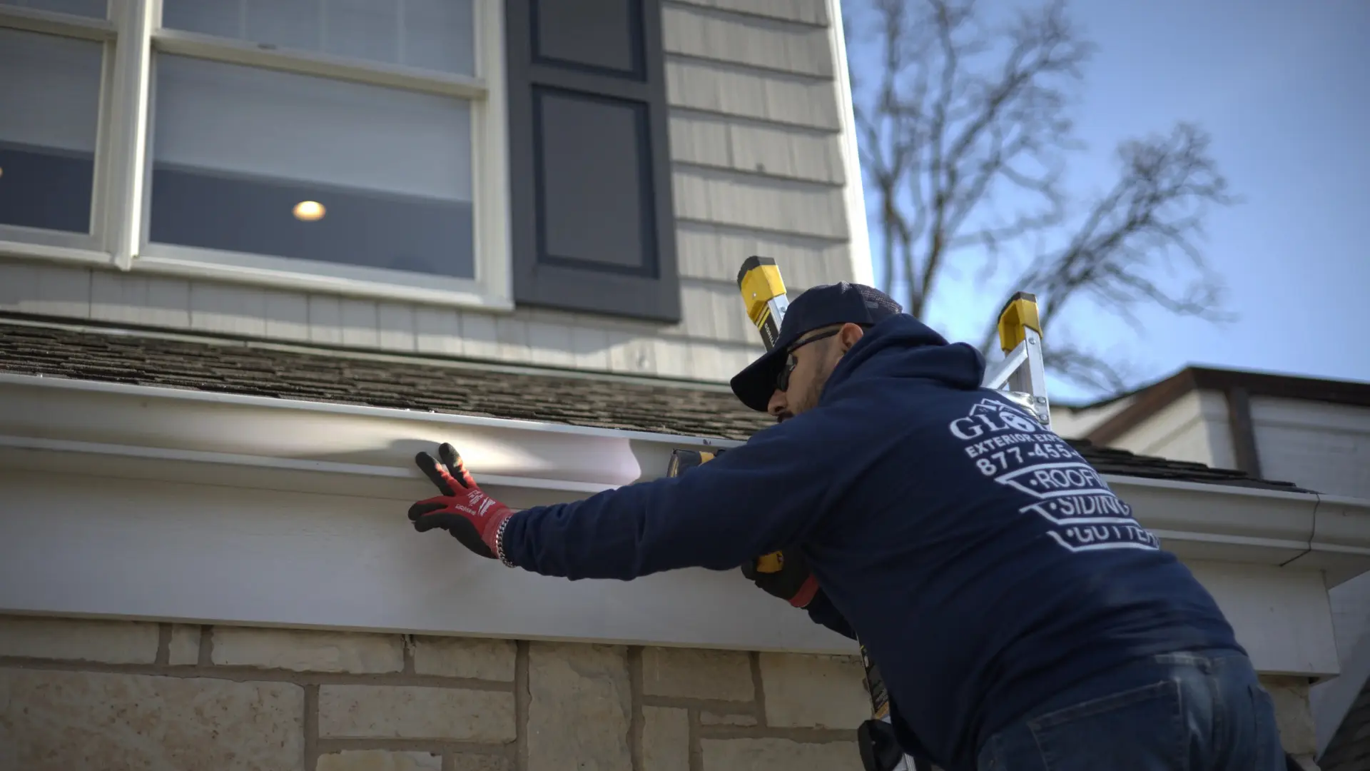 Aaron the owner of global exterior experts inspecting the gutters on a storm damaged residential home