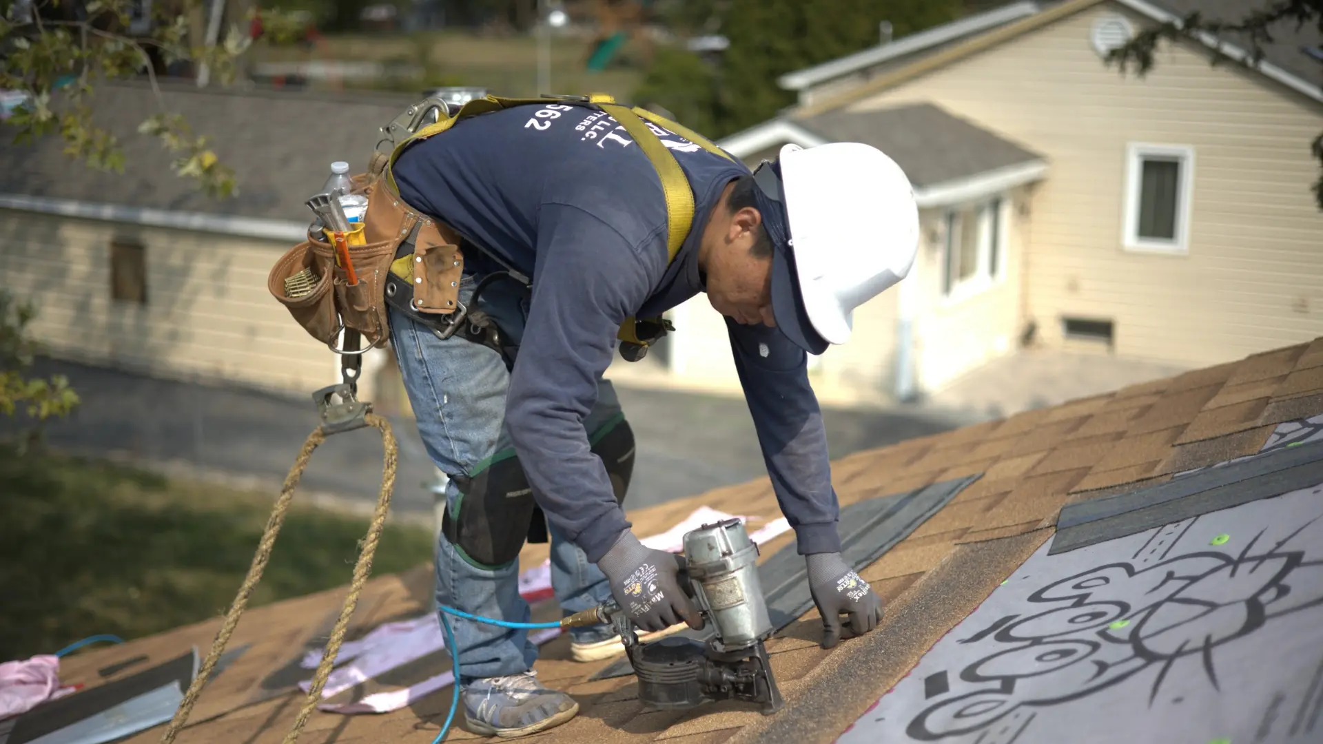 Roofer putting on roof on residential house