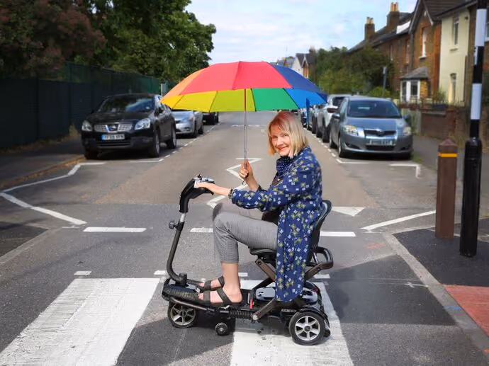 elderly lady crossing road on mobility scooter
