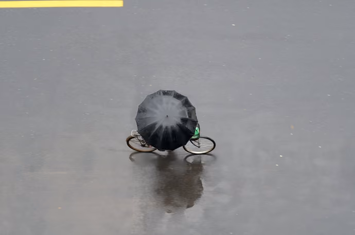 overhead shot of cyclist riding with umbrella