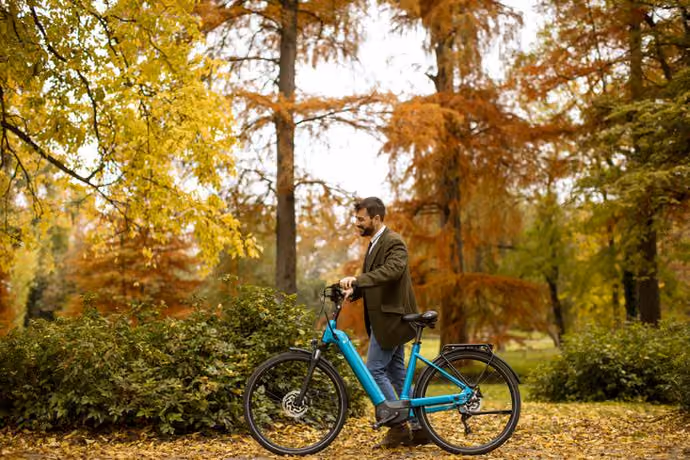 young man with electric bicycle in the autumn