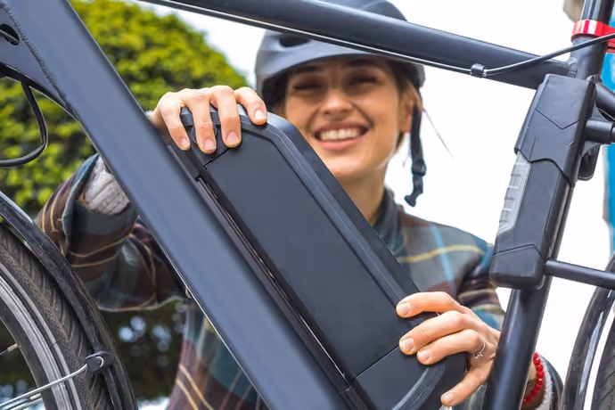 woman removing battery from e-bike