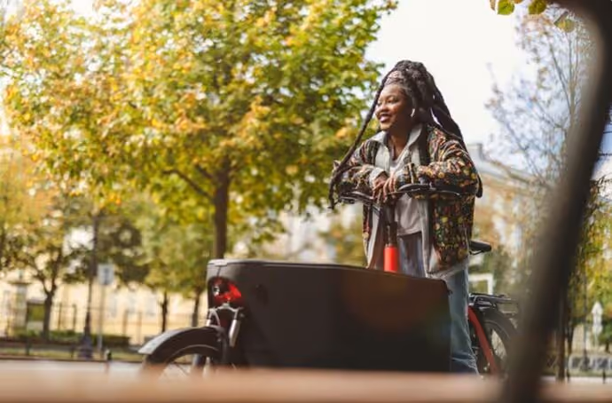 woman standing astride a cargo e-bike
