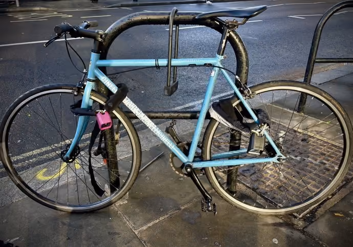 Bicycle locked to Sheffield stand in London using three different locks: one silver-rated, the second silver-rated and the third gold-rated.