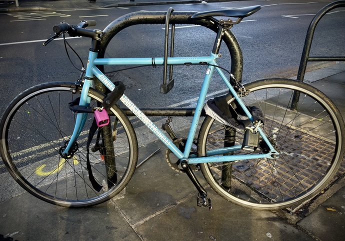 Bicycle locked to Sheffield stand in London using three different locks: one silver-rated, the second silver-rated and the third gold-rated.