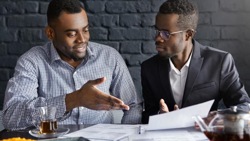 two african american businessmen discussing commercial real estate investment loans