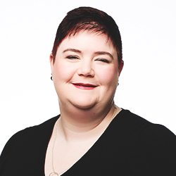 Smiling woman with short, dark hair in a black, V-neck shirt.