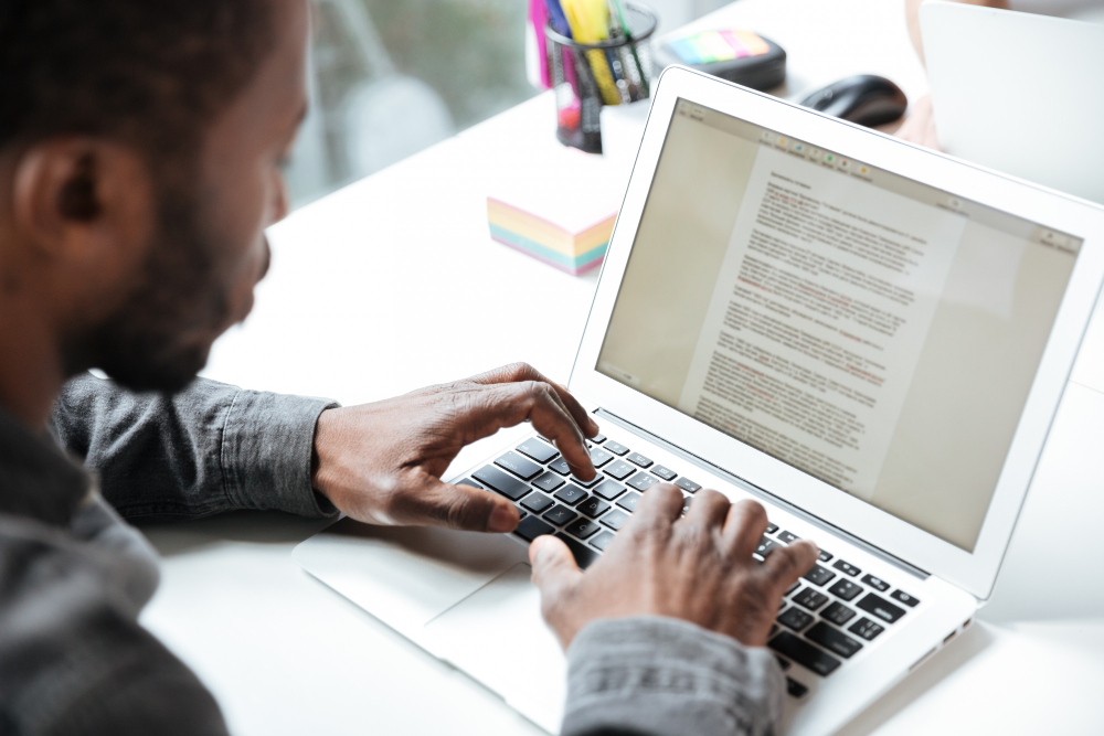 man typing on a laptop - Types of Essay Writing