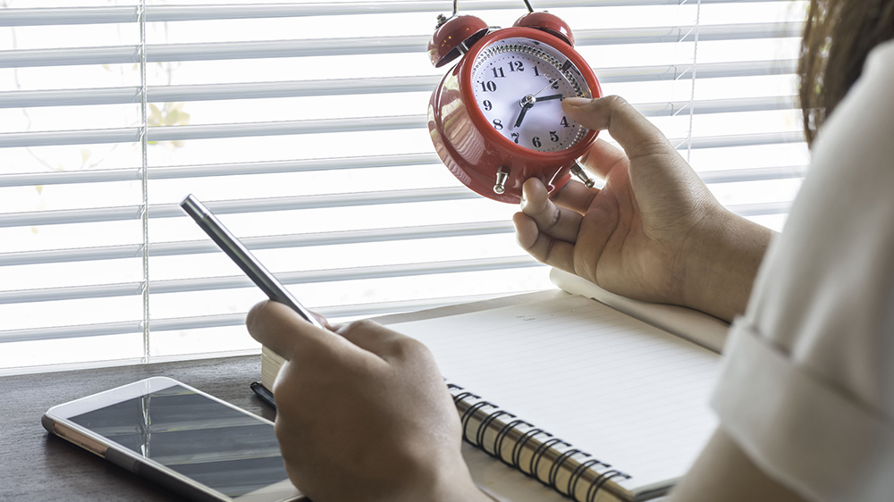 man looking at a clock - How Many Hours Do College Students Study per Week