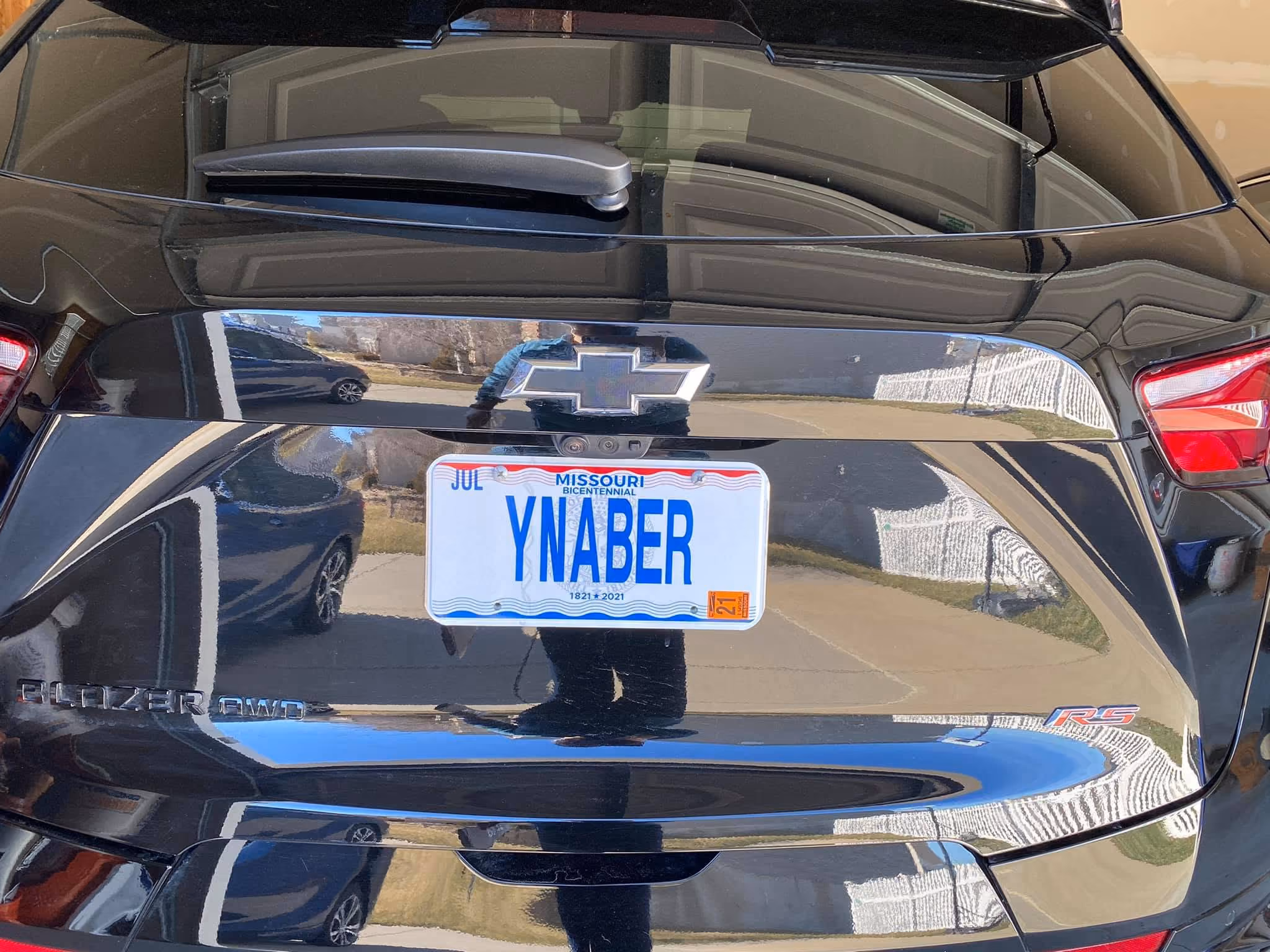 Rear view of a black Chevrolet car with a Missouri state bicentennial license plate reading 'YNABER'.