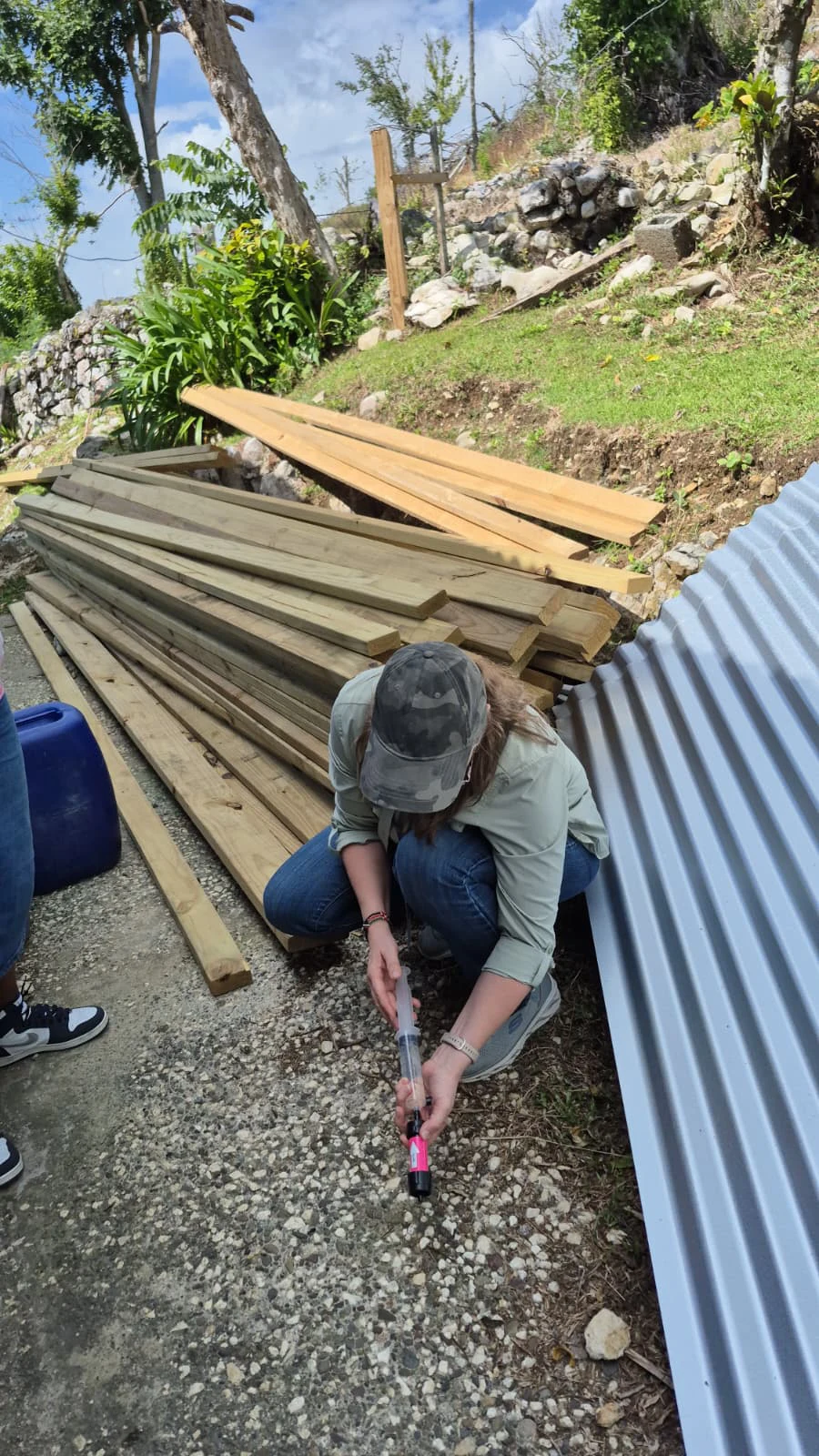 Person filtering water from Sawyer filter