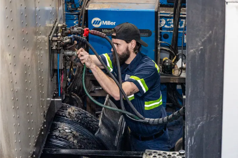Diesel mechanic providing preventive maintenance services on heavy-duty truck in Janesville, WI